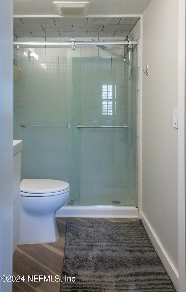 bathroom with a shower with door and toilet