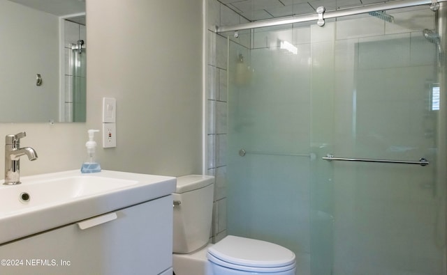 bathroom featuring vanity, toilet, and a shower with door