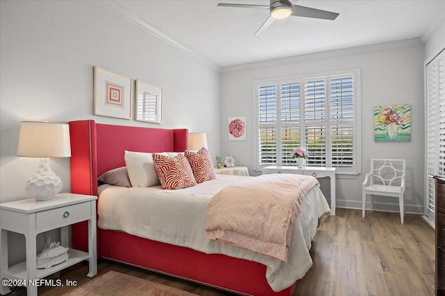 bedroom featuring ceiling fan, hardwood / wood-style flooring, ornamental molding, and a textured ceiling