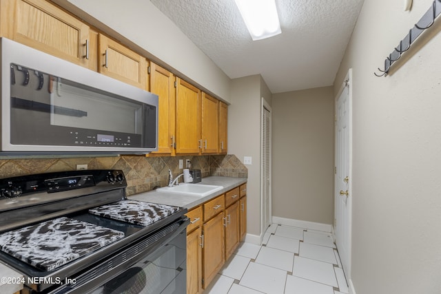 kitchen featuring sink, backsplash, a textured ceiling, and electric range