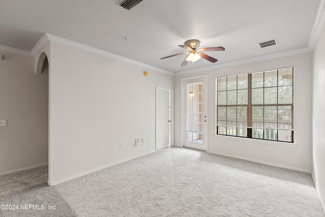 spare room with ceiling fan, ornamental molding, and light colored carpet