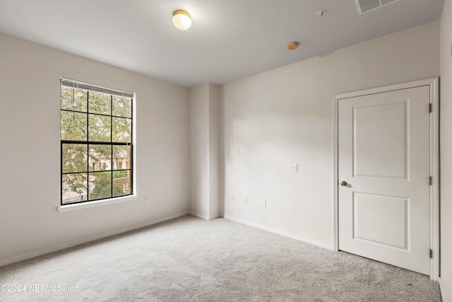 unfurnished room featuring light colored carpet