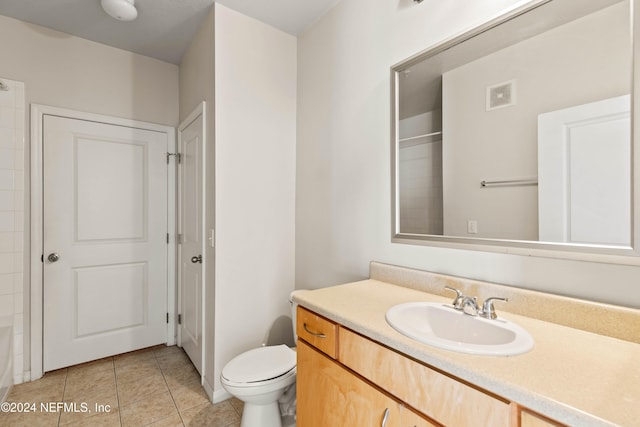 bathroom featuring vanity, toilet, a shower, and tile patterned flooring