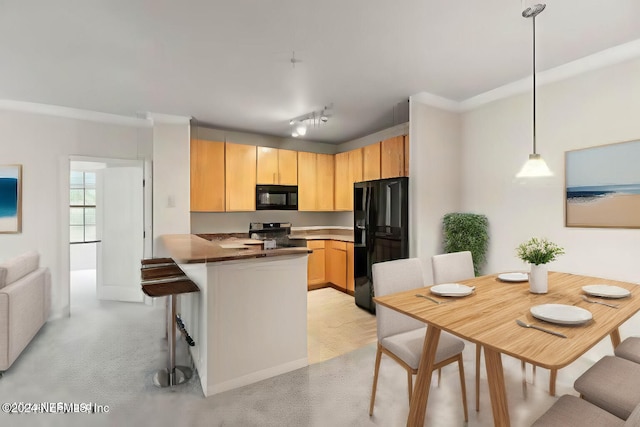 kitchen with black appliances, kitchen peninsula, hanging light fixtures, light brown cabinets, and light colored carpet