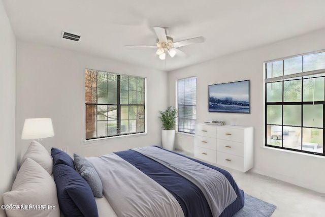 carpeted bedroom featuring ceiling fan and multiple windows