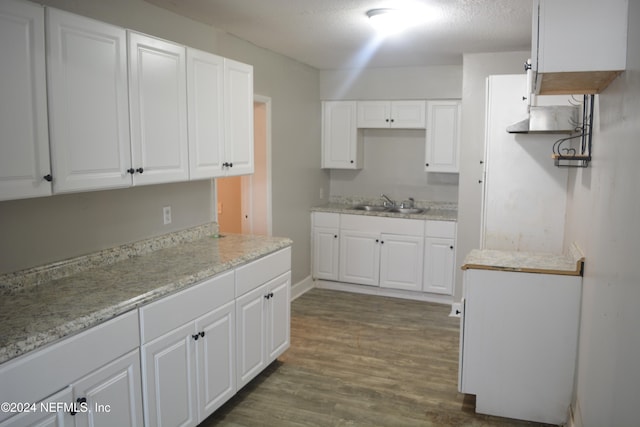 kitchen featuring white cabinets, sink, dark wood-type flooring, and a textured ceiling