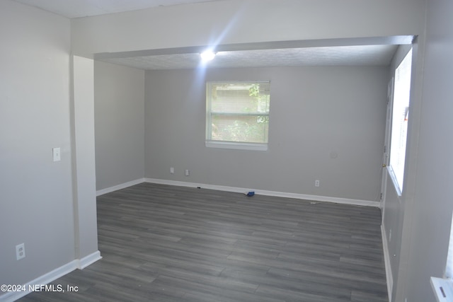 empty room featuring dark wood-type flooring and a textured ceiling