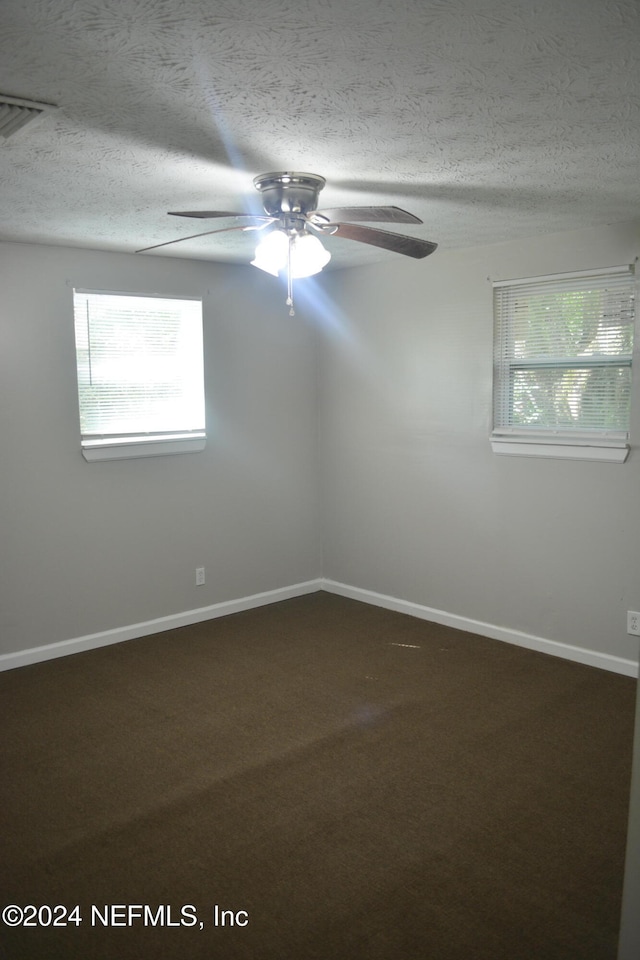 carpeted empty room featuring ceiling fan and a textured ceiling