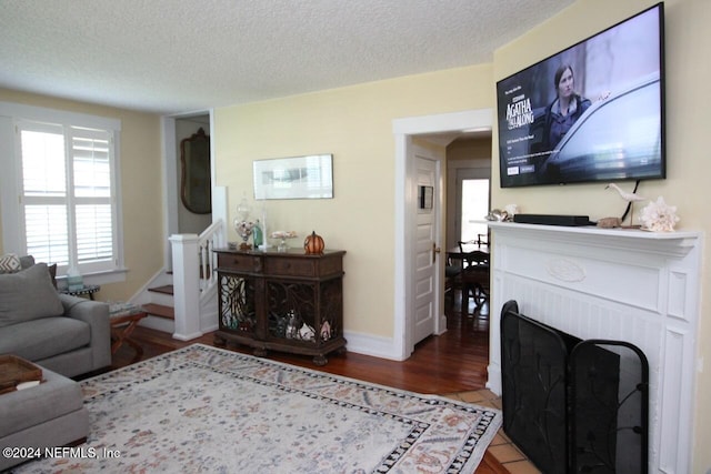 living room featuring a textured ceiling, a fireplace, and hardwood / wood-style floors