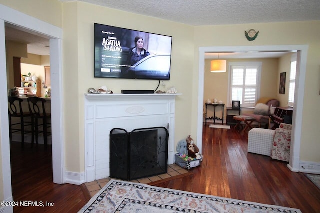 living room with dark wood-type flooring and a textured ceiling