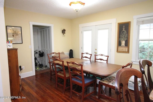 dining area featuring dark wood-type flooring and a textured ceiling