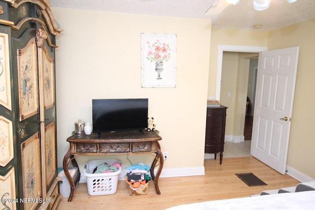 bedroom featuring ceiling fan, a textured ceiling, and hardwood / wood-style floors