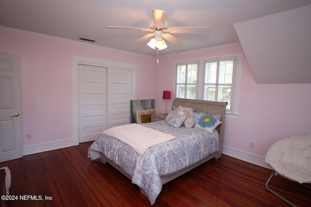 bedroom featuring dark wood-type flooring, ceiling fan, a closet, and a textured ceiling