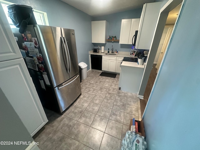 kitchen with lofted ceiling, sink, white cabinets, light tile patterned flooring, and appliances with stainless steel finishes