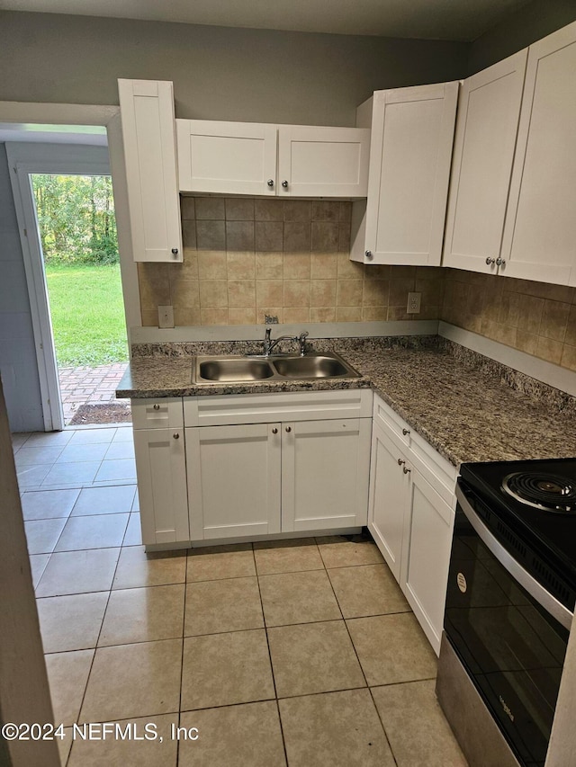 kitchen featuring white cabinetry, light tile patterned flooring, sink, and electric range