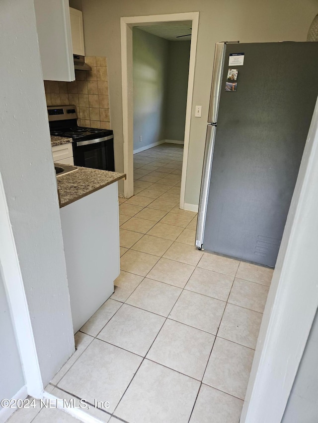 kitchen with stainless steel refrigerator, range with electric stovetop, ventilation hood, white cabinets, and decorative backsplash