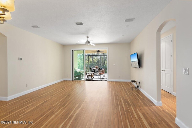 136 Pescado Dr, Saint Augustine, FL 32095 - empty room featuring arched walkways, light wood finished floors, a ceiling fan, and baseboards