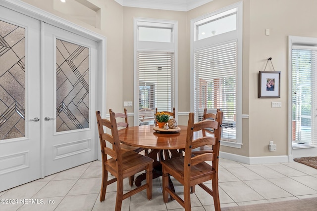 dining room featuring a wealth of natural light, french doors, light tile patterned floors, and crown molding