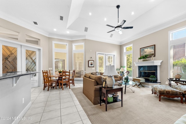 tiled living room featuring a premium fireplace, ceiling fan, and ornamental molding