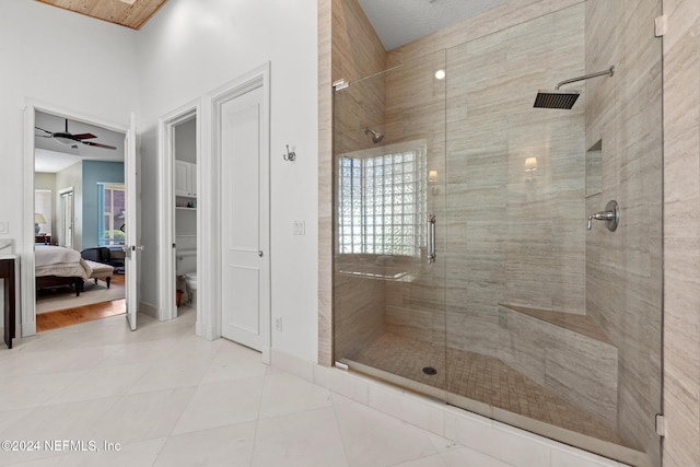 bathroom featuring tile patterned flooring, ceiling fan, toilet, and a shower with shower door