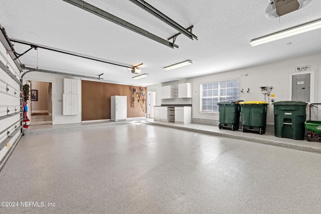 garage with a garage door opener and white fridge