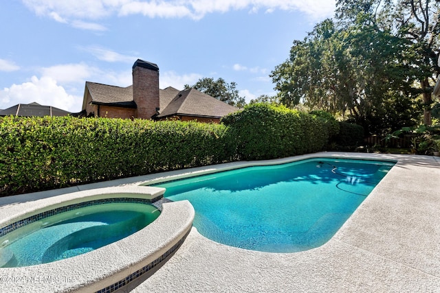 view of swimming pool featuring an in ground hot tub