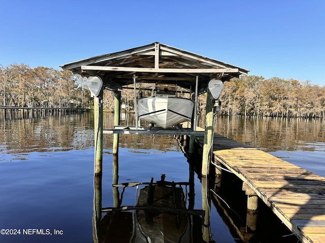 dock area featuring boat lift and a water view