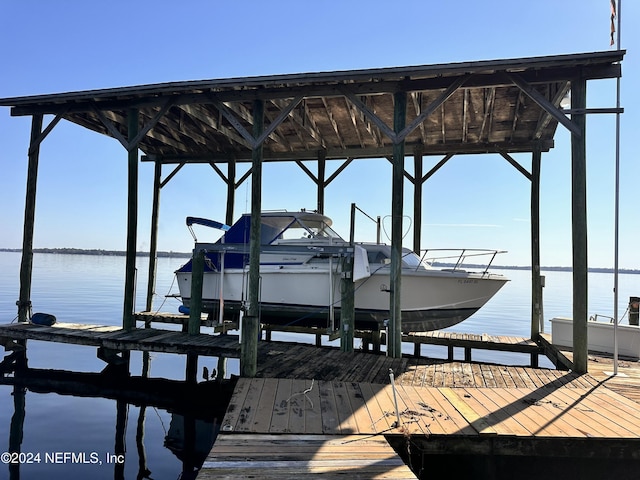 dock area with boat lift and a water view