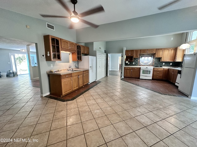 kitchen with backsplash, a ceiling fan, visible vents, light tile patterned floors, and white appliances