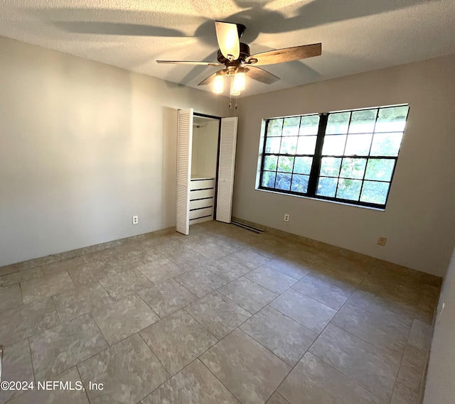 unfurnished bedroom with a closet, a textured ceiling, and ceiling fan