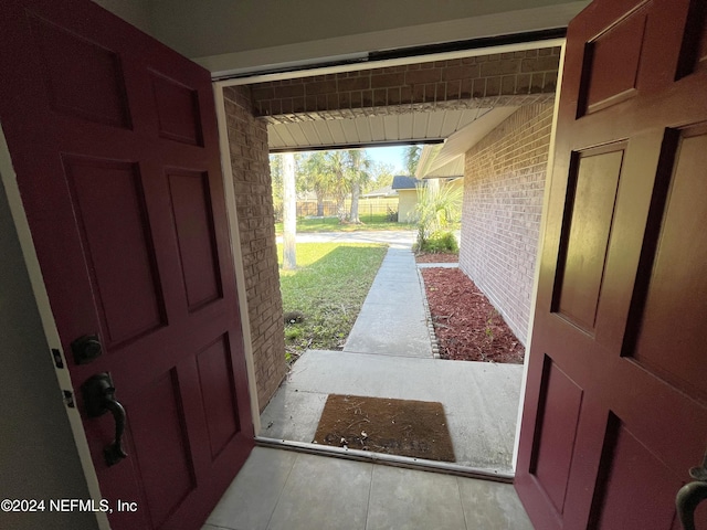 entrance foyer featuring brick wall