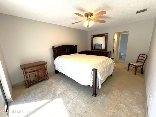 bedroom with a textured ceiling, ensuite bathroom, and ceiling fan