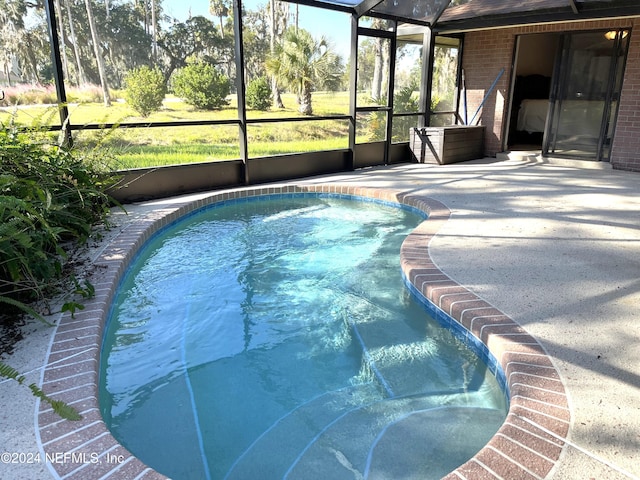 view of swimming pool with a patio and glass enclosure