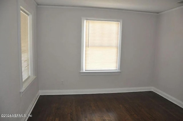 spare room featuring ornamental molding and dark hardwood / wood-style flooring