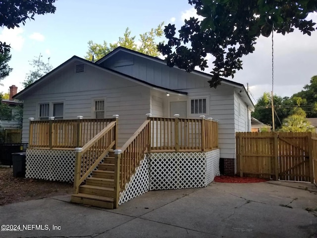 back of house with a deck and a patio area