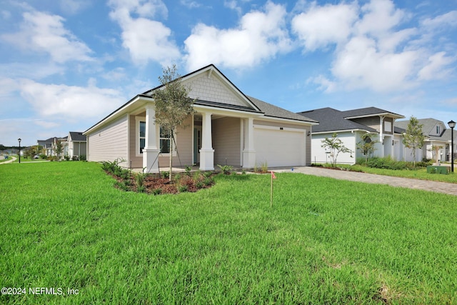 view of front facade with a garage, covered porch, and a front yard