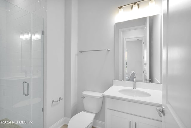 bathroom with a shower with door, vanity, and toilet