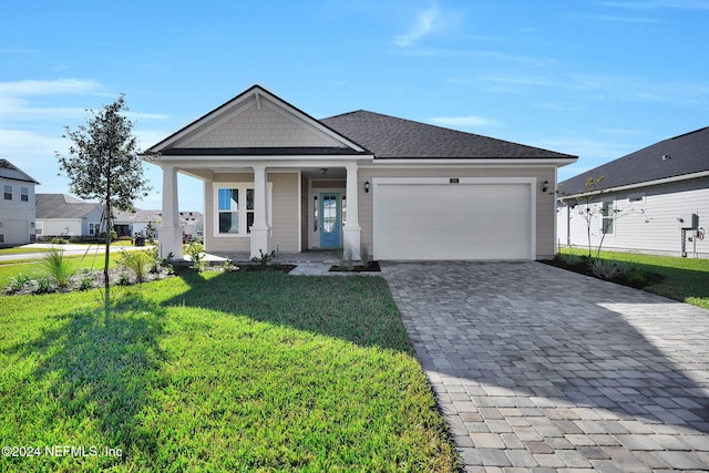 view of front of property with covered porch, a front yard, and a garage