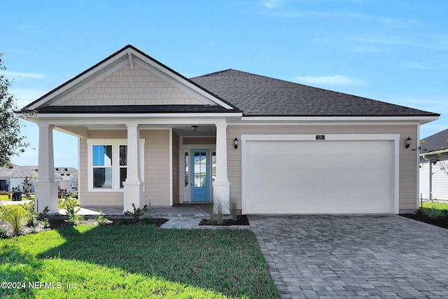 view of front of house with a front yard, a porch, and a garage