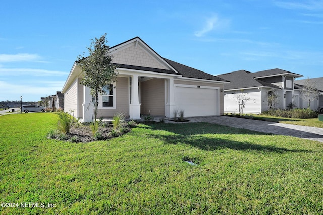 view of front of property featuring covered porch, a front yard, and a garage