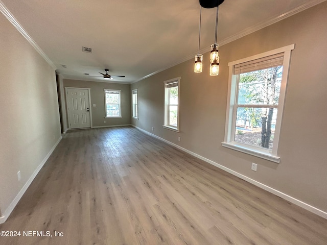 spare room featuring a wealth of natural light, ornamental molding, and hardwood / wood-style flooring