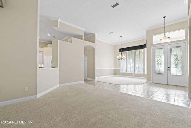 entrance foyer with light colored carpet, a chandelier, and ornamental molding