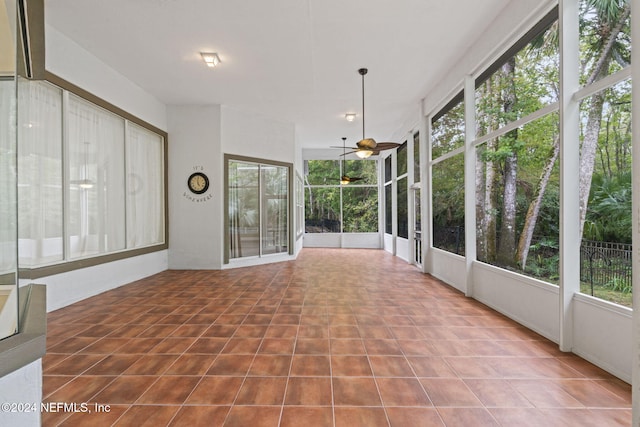 unfurnished sunroom featuring ceiling fan