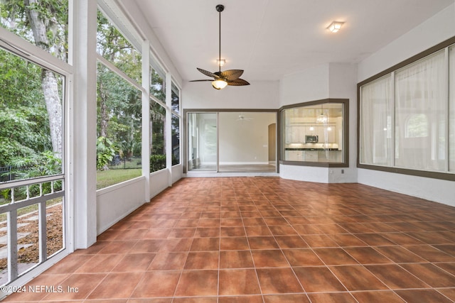 unfurnished sunroom featuring ceiling fan