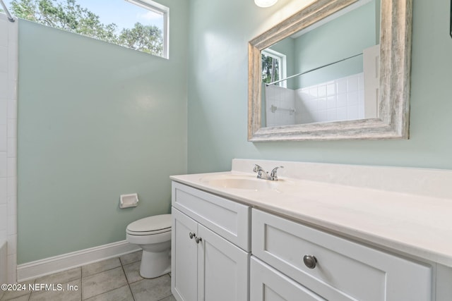 bathroom featuring toilet, a shower, tile patterned floors, and plenty of natural light