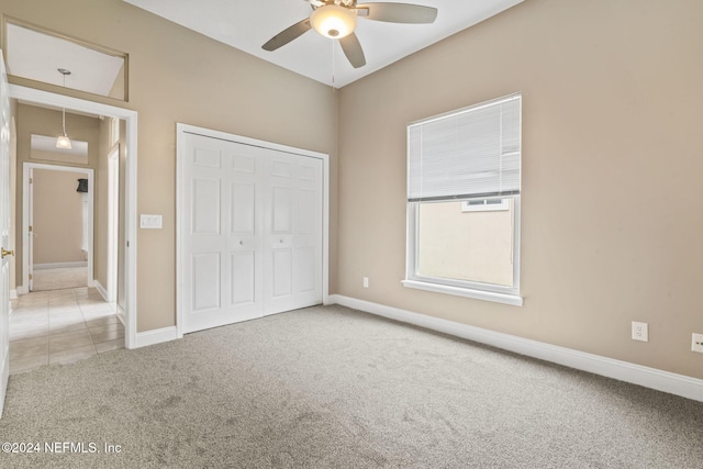 unfurnished bedroom featuring light carpet, ceiling fan, and a closet