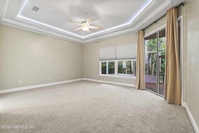 unfurnished room featuring ornamental molding, carpet floors, ceiling fan, and a tray ceiling