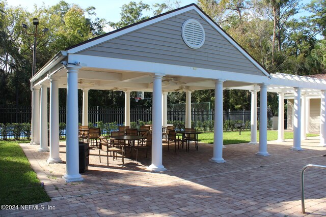 view of property's community featuring a lawn and a patio area