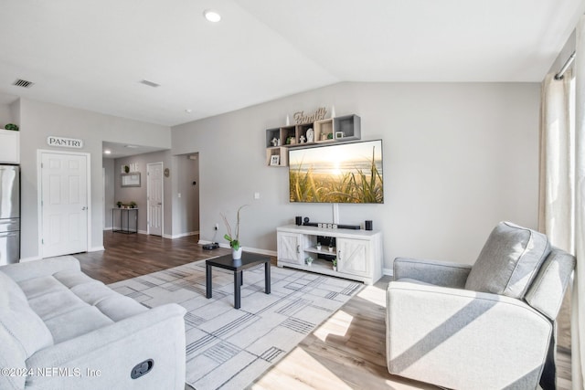 living room featuring lofted ceiling and light hardwood / wood-style flooring