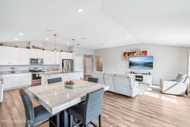 dining room featuring vaulted ceiling and light wood-type flooring